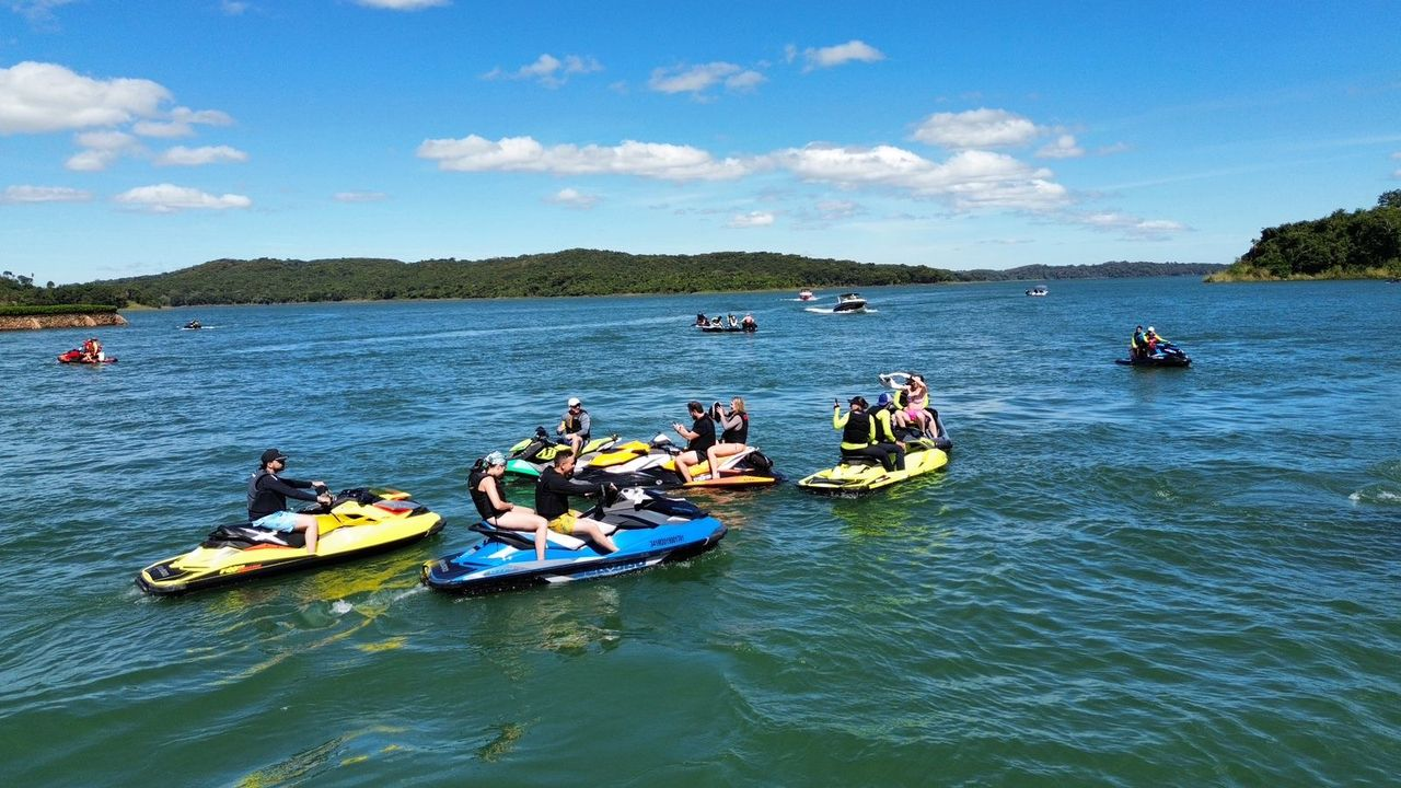 Grupo reunido sobre os jet skis em roda no meio do lago