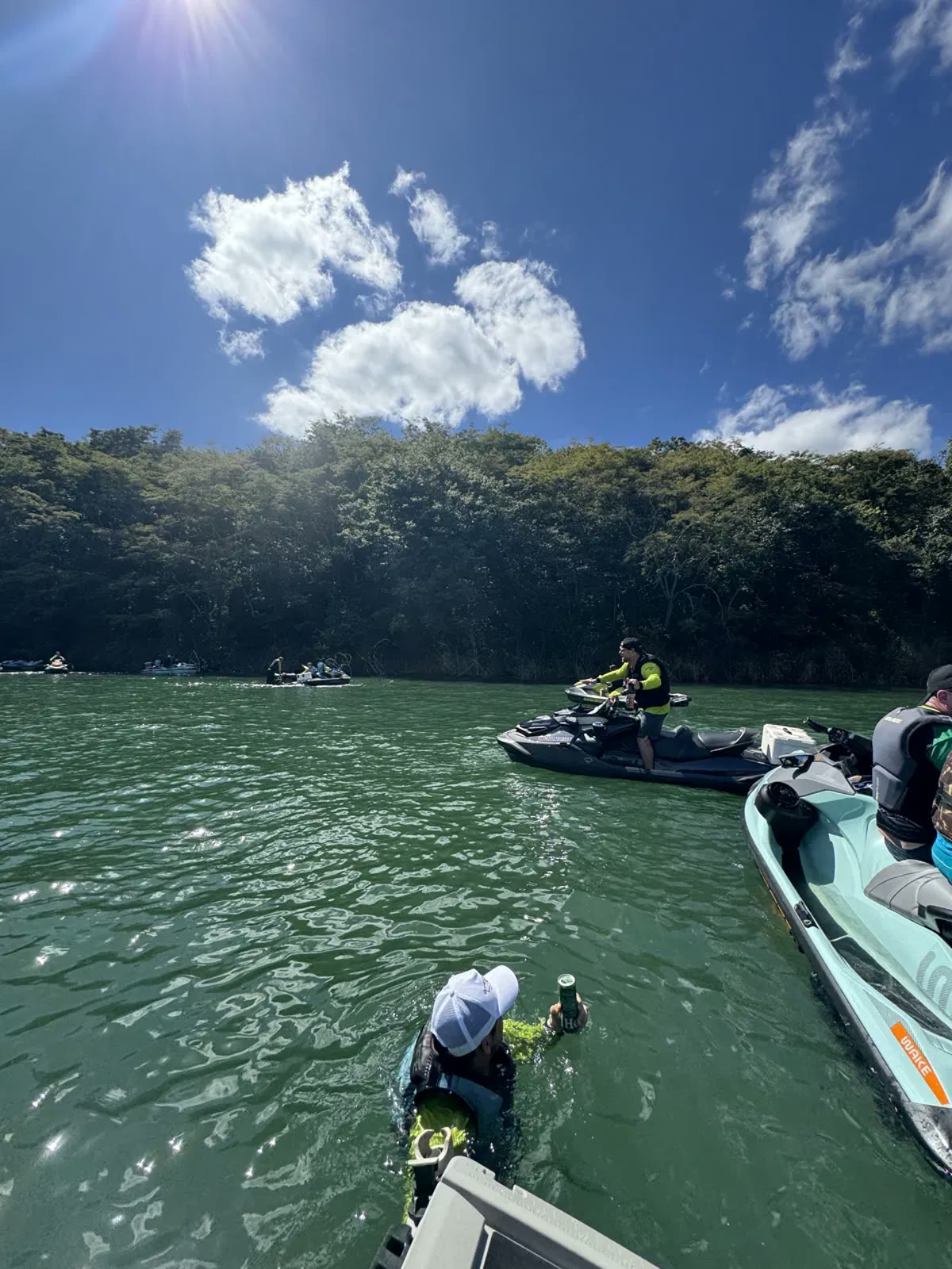 Parada na água com jet skis e mata nativa ao fundo